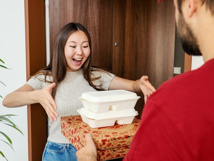 A smiling customer receiving a food delivery at her door