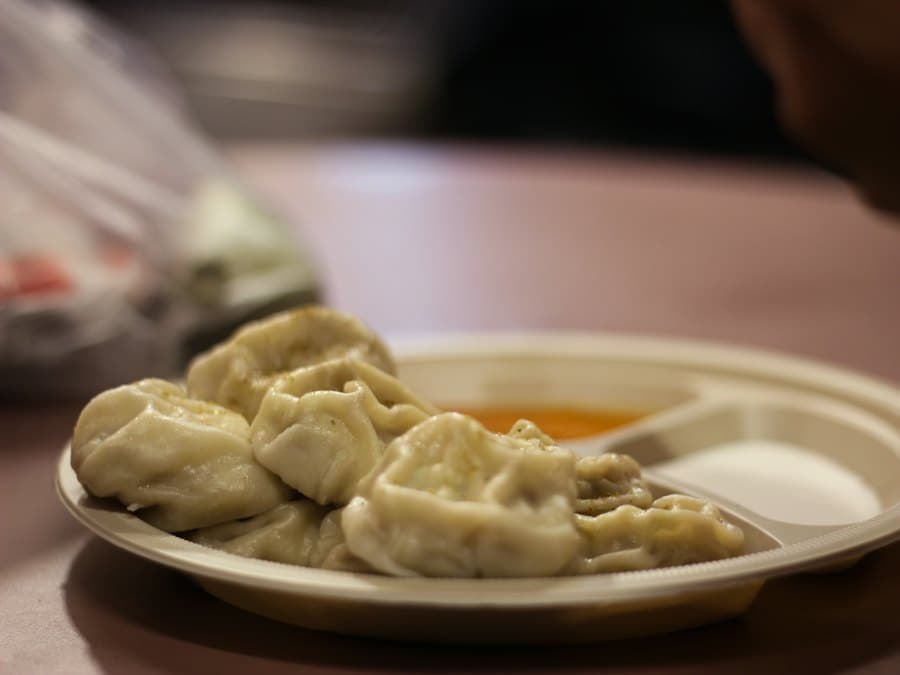 A plate of steamed momo with tomato achar